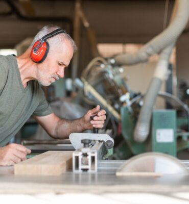 Profesional utilizando una sierra de mesa para madera en un taller de carpintería