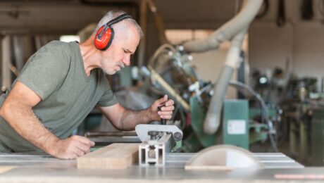 Profesional utilizando una sierra de mesa para madera en un taller de carpintería